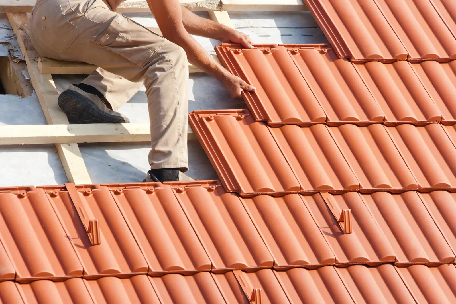 Roofer installing tiles on a roof